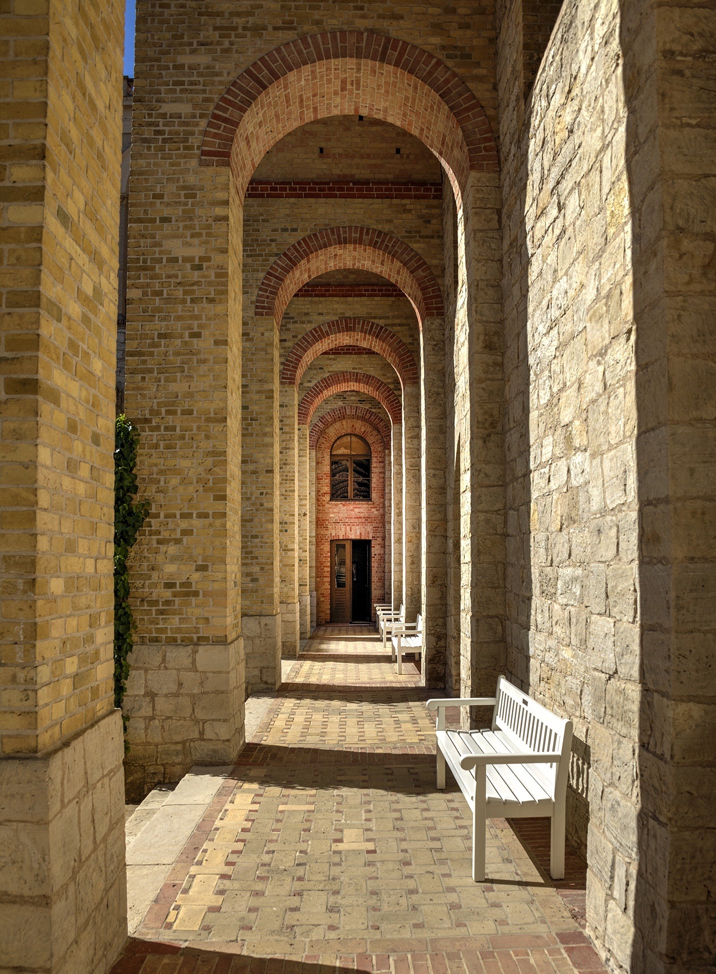 brick walkway with bench leading to door